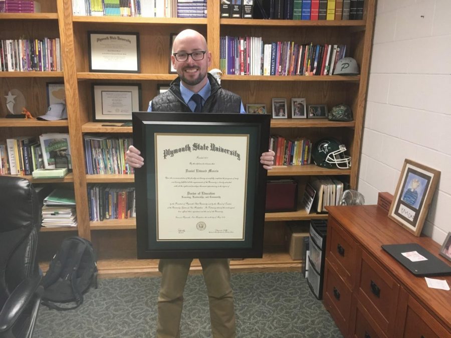 Mr. Morris holding his Ed.D diploma.