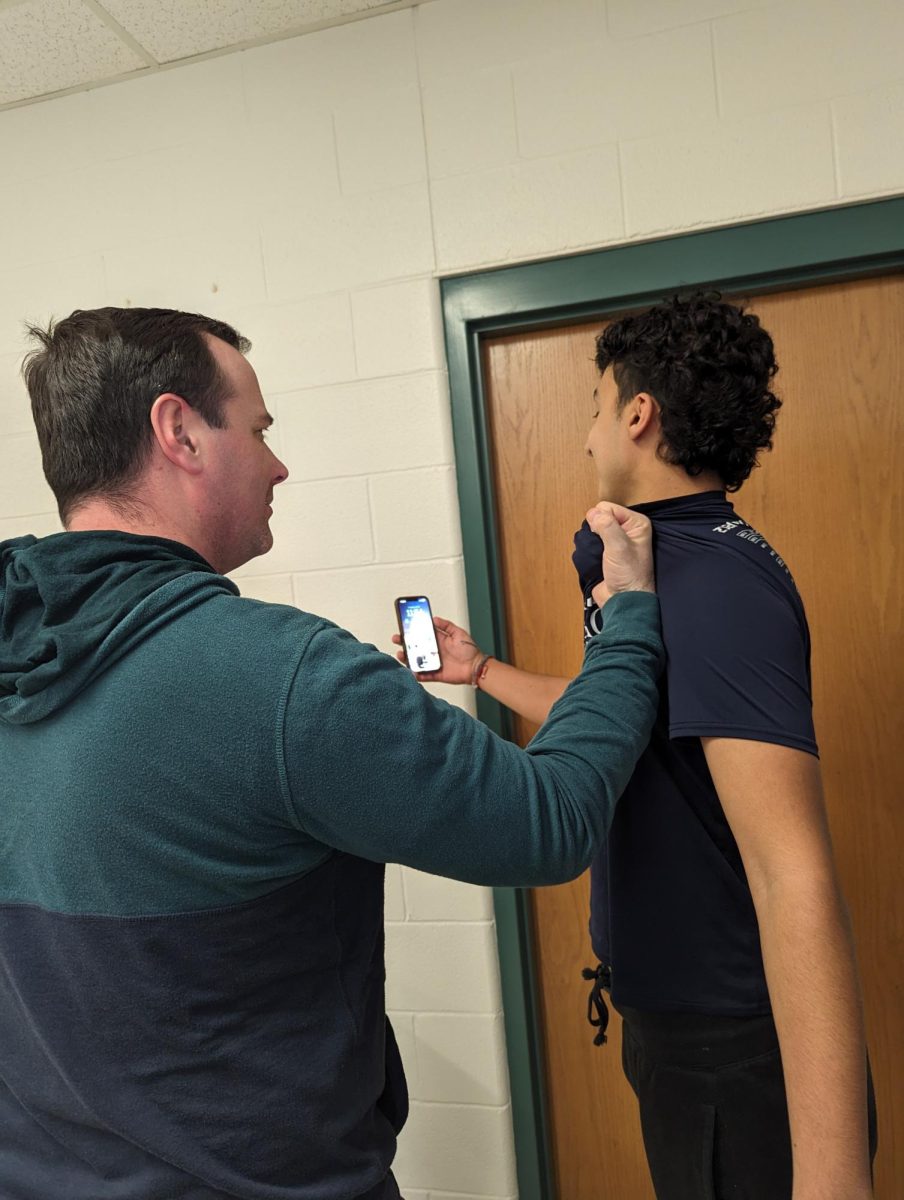 English teacher Mr. Dee tries to pose for a picture with staff writer Abdalla Faiad, but Faiad wont get off his phone. 